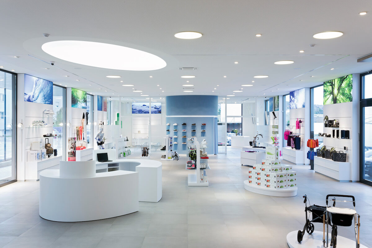 Unterschiedliche Lichtinszenierung durch unterschiedliche Anforderungen im Vital-Zentrum Glotz: Flächenlicht über der Kasse, hinterleuchtete Großfotos, Grundlicht und verstellbare Einbaustrahler zur Akzentuierung der Produkte im lichttechnischen Gesamtkonzept. (Foto: Bettina Matthiessen)